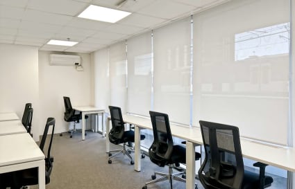 Modern coworking space with ergonomic chairs, ample natural light, and a minimalist design.