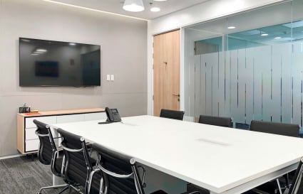 Modern conference room with sleek furnishings, whiteboard, and ample natural light. Perfect for collaboration.