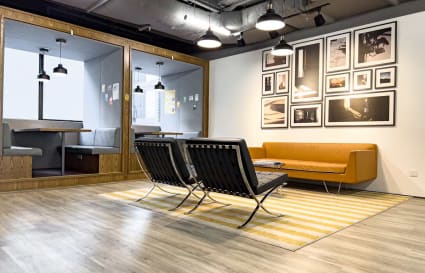 Modern coworking space with stylish seating, warm lighting, and a chic gallery wall.