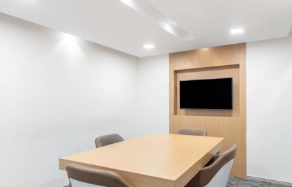 Sleek meeting room with modern table, ergonomic chairs, and built-in screen. Ideal for collaboration.
