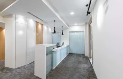 Modern coworking reception area with sleek design, ample lighting, and elegant finishes.