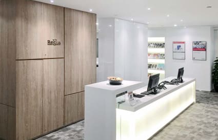 Modern reception area with sleek design and warm lighting in Queen's Road Central coworking space.