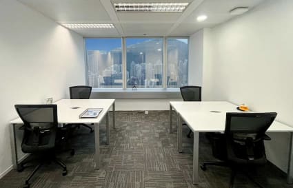 Modern coworking space with natural light, ergonomic chairs, and cityscape views.
