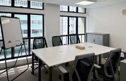 Modern coworking space with natural light, ergonomic chairs, and a whiteboard on Hennessy Road.