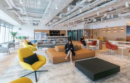 Modern coworking space with vibrant seating, open layout, and abundant natural light.
