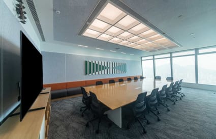 Modern conference room with a large table, ergonomic chairs, and panoramic city views.