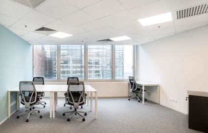 Modern coworking space with ample natural light, ergonomic chairs, and flexible desk arrangements.