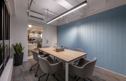 Modern meeting room with a minimalist design, comfortable seating, and ample natural light.