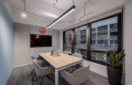 Bright meeting room with modern furniture and large windows overlooking bustling 德輔道中.