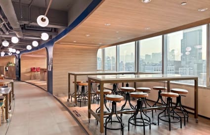 Modern coworking space with city views, dynamic seating, and abundant natural light.
