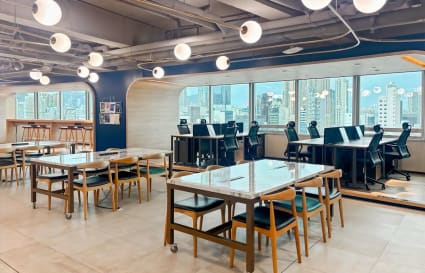 Bright, open coworking space with city views, modern seating, and stylish lighting.