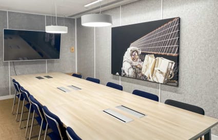 Modern meeting room with sleek design, spacious table, and advanced AV setup in Canton Road coworking space.
