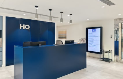 Modern reception with sleek blue desk and digital directory in Nathan Road coworking space.