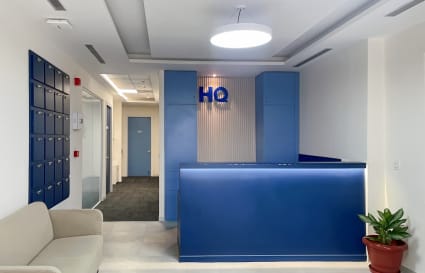 Modern reception area with chic blue accents, cozy seating, and ample natural light on Haridwar Bypass Road.