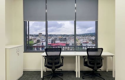 Bright coworking space with city views, ergonomic chairs, and ample natural light.
