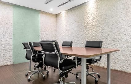 Modern meeting room with sleek chairs and textured walls in a flexible coworking space.