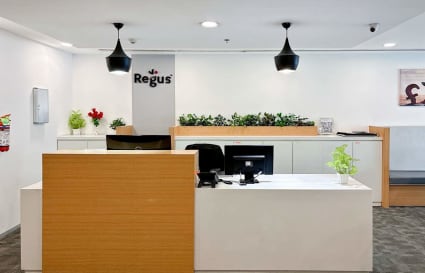 Modern coworking area with sleek reception, ample lighting, and greenery in Northern Access Road.