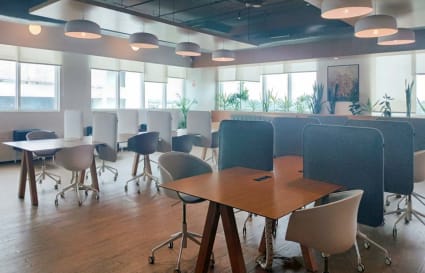Modern coworking space with ample natural light, stylish desks, and ergonomic seating.