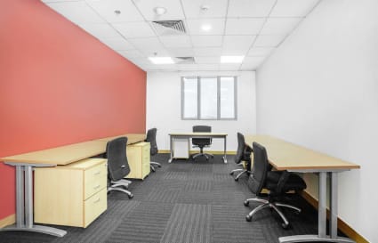 Modern coworking space with natural light, ergonomic chairs, and ample desk space.