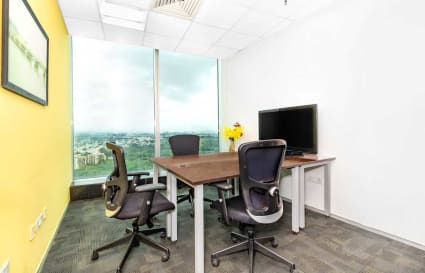 Bright coworking space with a view, featuring ergonomic chairs and a sleek desk setup.