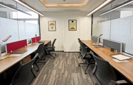 Modern coworking space with sleek desks, ergonomic chairs, and ample natural light.