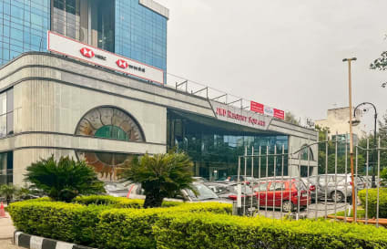 Modern coworking space on Mehrauli-Gurgaon Road with ample parking and lush greenery.