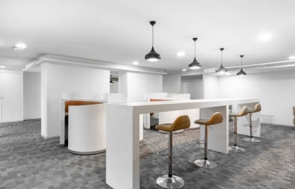 Modern coworking area with high desks and barstool seating, ideal for collaboration.