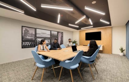 Modern coworking space with stylish lighting, cozy seating, and a collaborative meeting area.
