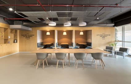 Modern coworking space with open seating, cozy booths, and abundant natural light.