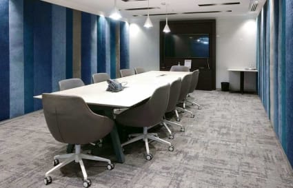 Modern meeting room with stylish chairs, sleek table, and vibrant striped wall panels.