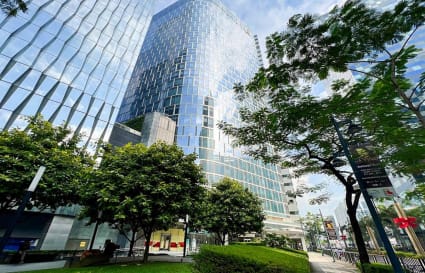 Modern coworking space on Metro Manila's 5th Avenue, featuring sleek architecture and lush greenery.