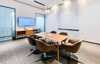 Modern coworking space with sleek conference area, ample lighting, and AV setup. Ideal for meetings.