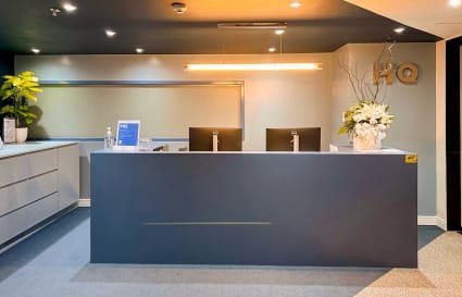 Modern reception area with sleek design, ambient lighting, and welcoming floral accents.