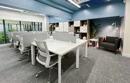 Modern coworking space with sleek desks, ergonomic chairs, and bright natural light.