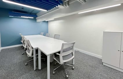 Modern coworking space with sleek white desks, ergonomic chairs, and soft ambient lighting.