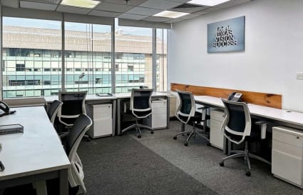 Bright coworking space with modern desks and natural light in Mandir Marg, Delhi.