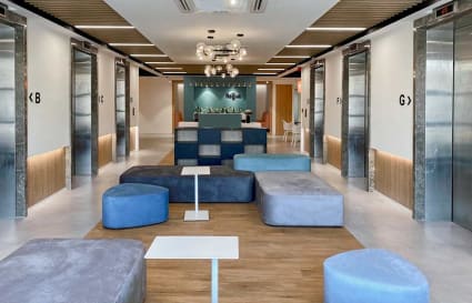 Modern coworking lounge with cozy seating, sleek elevators, and stylish lighting in Turbhe MIDC.