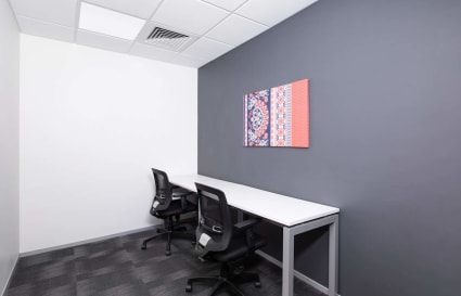 Sleek private office with modern furnishings and vibrant wall art for focused work sessions.