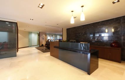 Sleek reception area with modern lighting and spacious layout in a flexible coworking space.