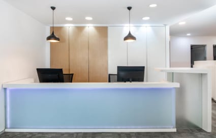 Modern reception area with sleek design, warm lighting, and ample workspace. Perfect for welcoming clients.