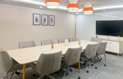 Modern conference room with a sleek table, ergonomic chairs, and vibrant lighting. Perfect for teams.