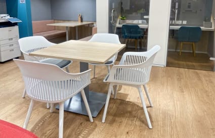 Modern coworking area with sleek furniture and wood flooring, perfect for collaboration.