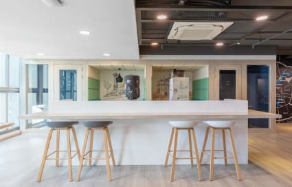 Modern coworking space with sleek bar seating and ample natural light. Ideal for collaboration.