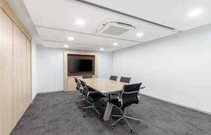 Modern meeting room with sleek chairs, large screen, and ample lighting on Judges Bunglow Road.
