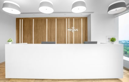 Sleek reception area with modern design and ample natural light in a coworking space.