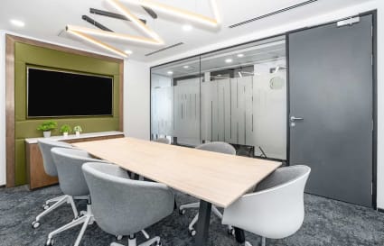 Sleek meeting room with modern design, ample natural light, and plush seating in a flexible coworking space.