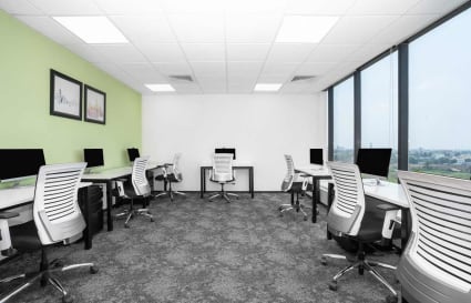 Bright and airy coworking space with modern desks, ergonomic chairs, and a scenic view.