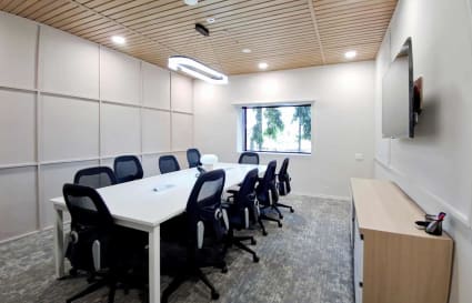 Modern conference room with ergonomic chairs, sleek table, and natural light on Thudiyalur - Saravanampatti Road.