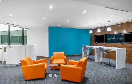 Modern coworking space with vibrant seating, sleek desks, and bright ambient lighting.