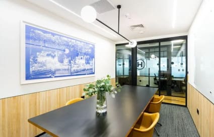 Modern meeting room with sleek table, stylish chairs, and elegant decor at Robinson Road coworking space.